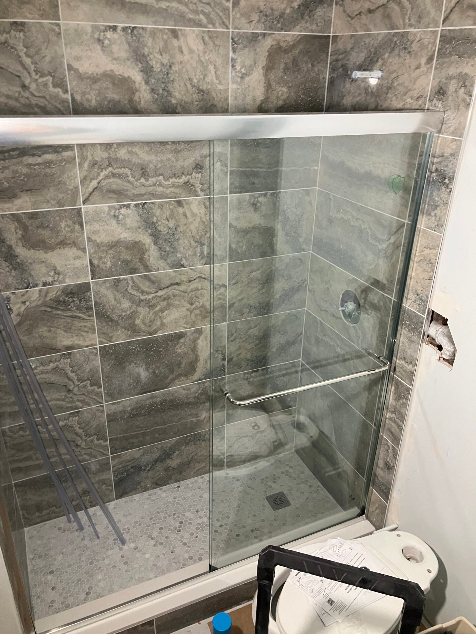 Shower with mosaic floor and grid tile surround in the Castro